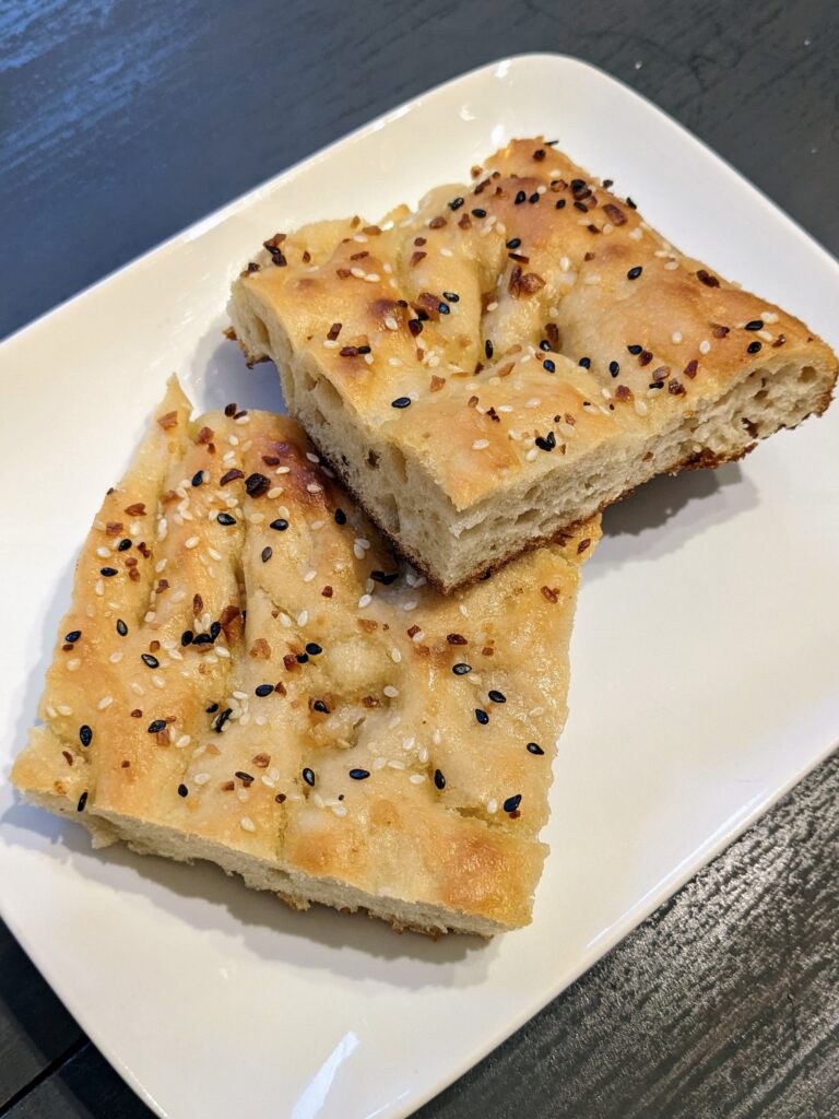 Everything Bagel Focaccia: two slices on a white rectangular plate