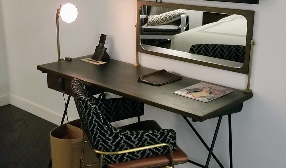 Modern desk with gold and navy chair and orb light