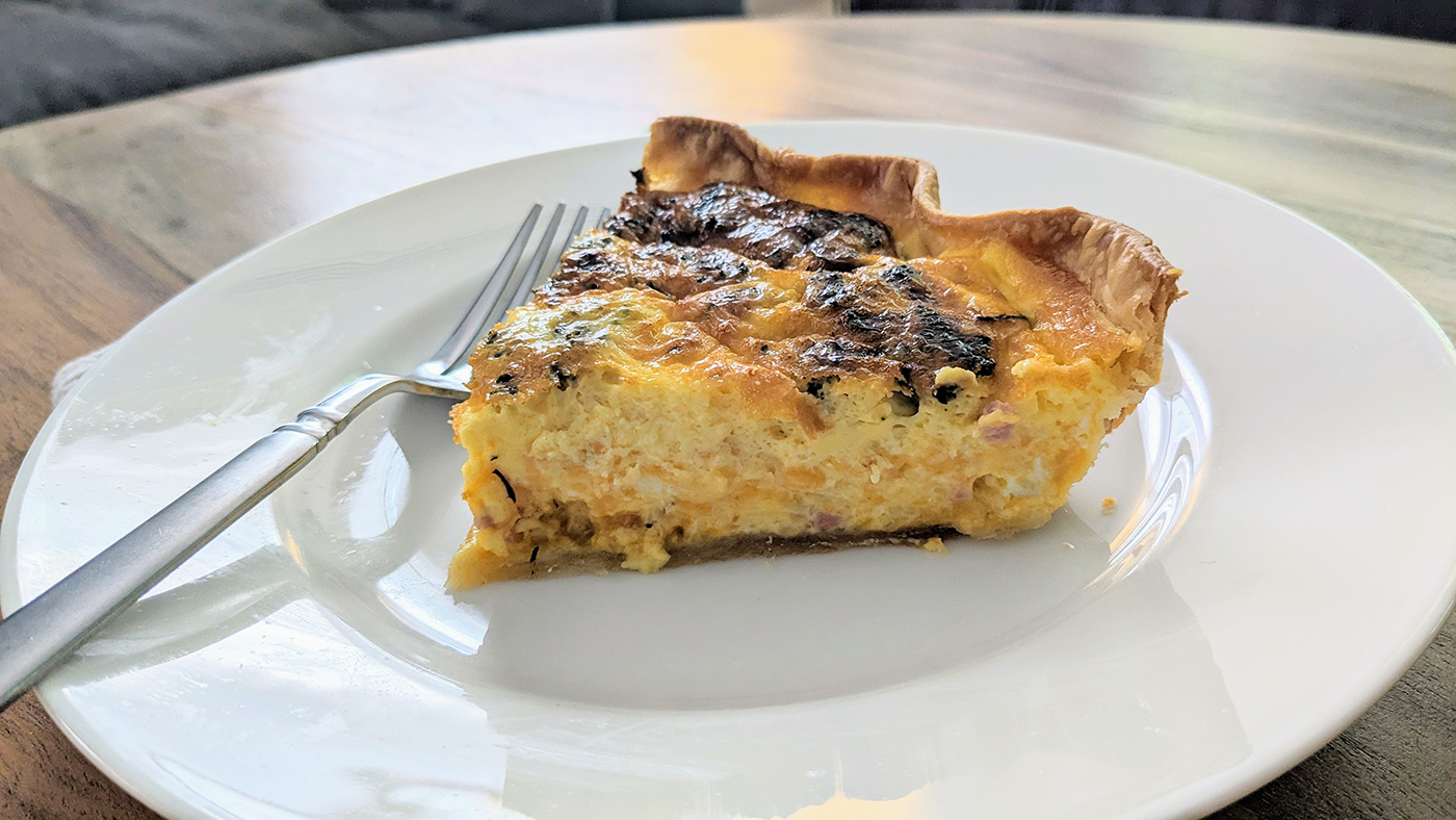 broccoli bacon cheddar quiche slice on plate