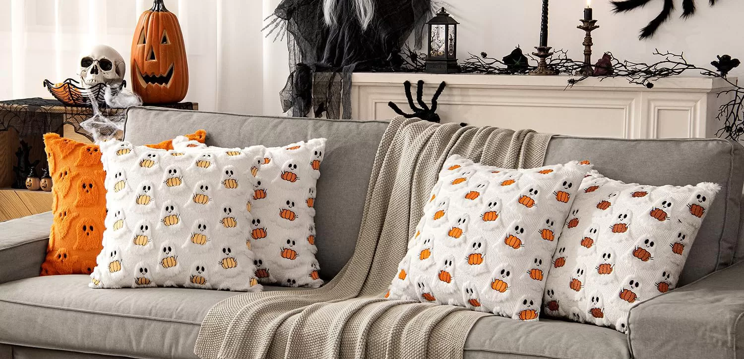 ghost pillows on a gray sofa, decorated for halloween using amazon items