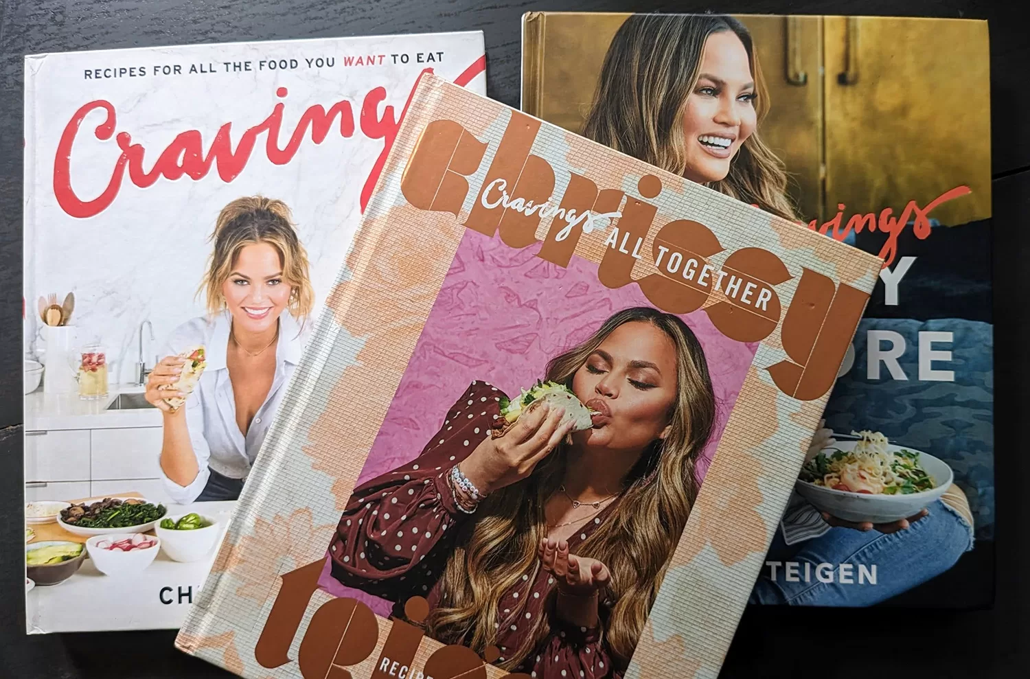 comparing all three Chrissy Teigen "Cravings" cookbooks, shown side by side