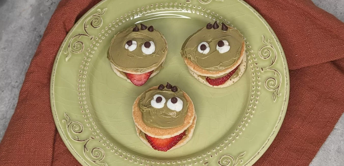 an easy halloween breakfast: strawberry pancake monsters with marshmallow eyes, shown close up