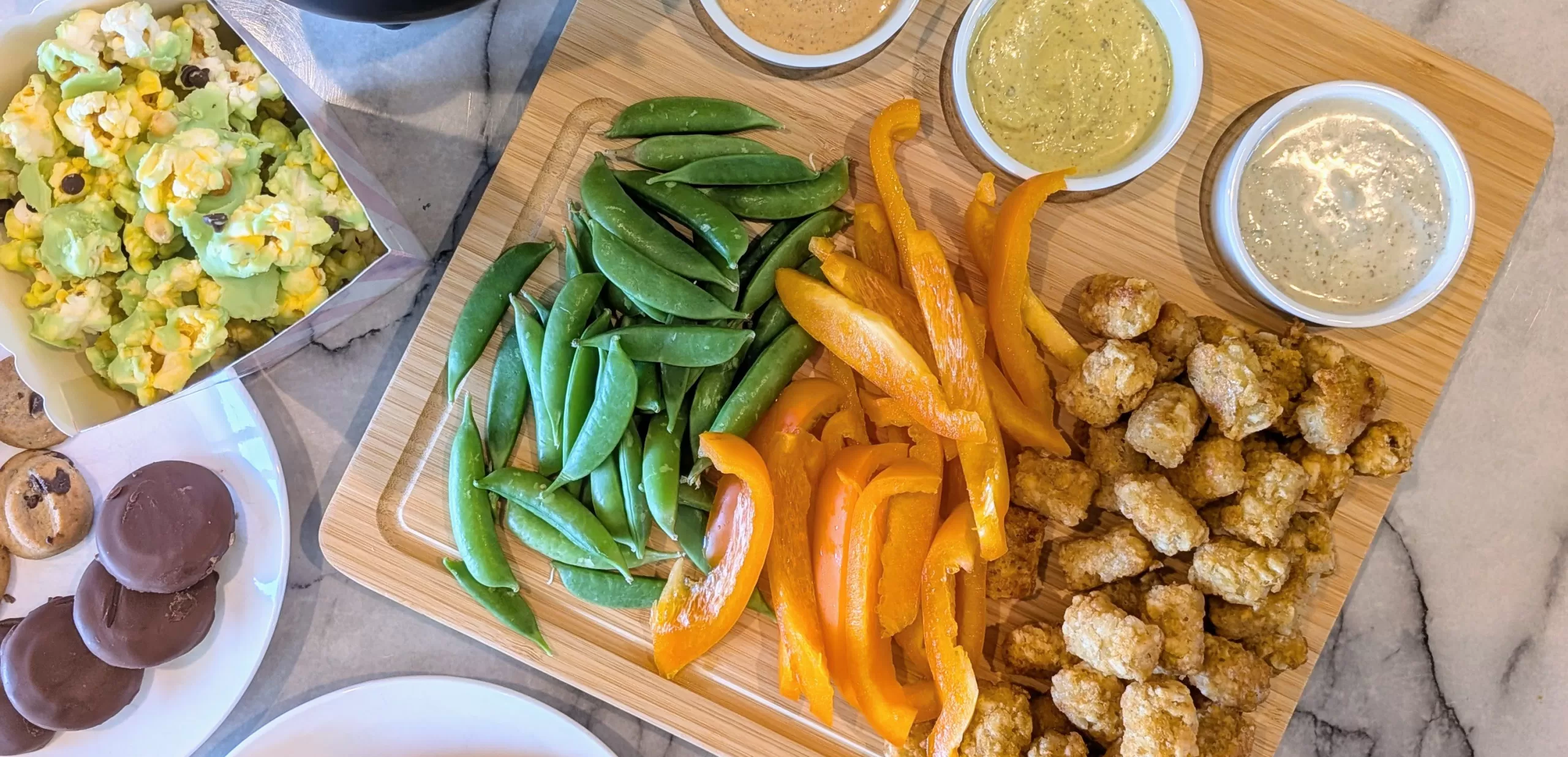 close up of crudi-tots platter featuring tater tots and sugar snap peas and bell peppers